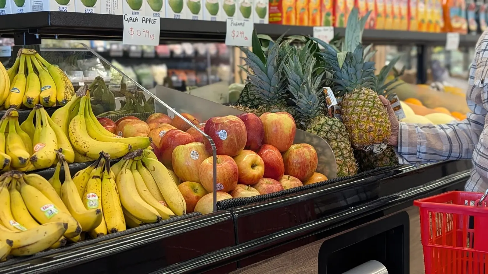 Bananas, apples and pineapples in the fresh produce case
